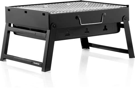 Barbacoa portátil de carbón sobre una mesa de exterior