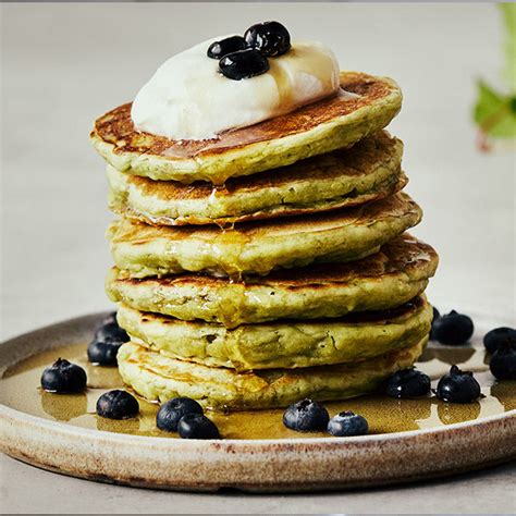 Plato de tortitas de té matcha con bayas y jarabe