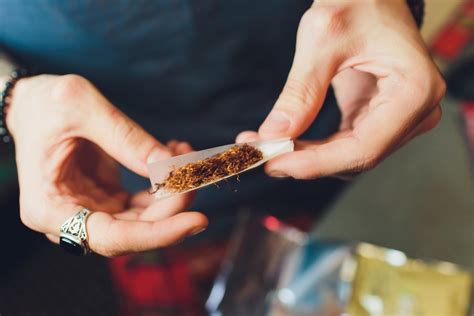 Persona enrollando un cigarrillo de marihuana