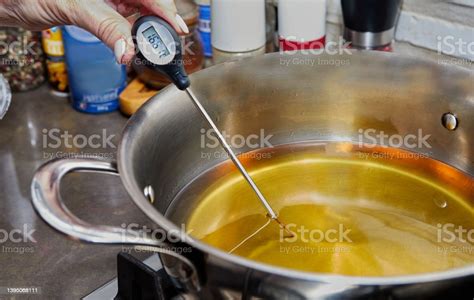 Termómetro de cocina midiendo la temperatura del aceite en la sartén