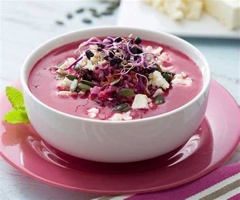 Plato de gazpacho de remolacha decorado con queso feta y pipas de calabaza
