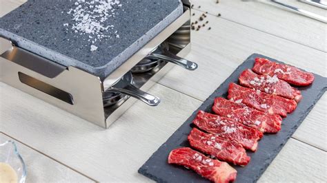 Mesa con carne a la piedra lista para cocinar
