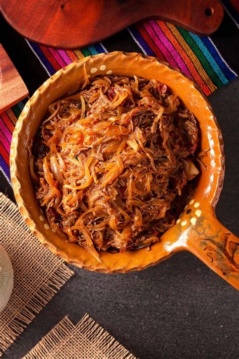 Tinga de res cociéndose en una sartén