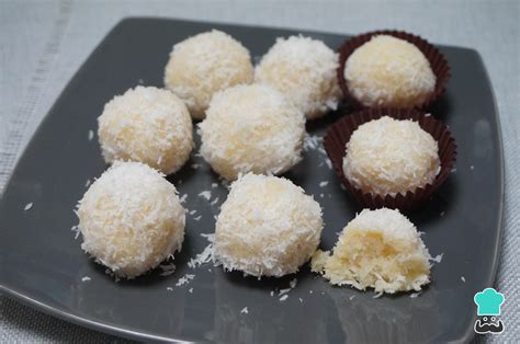 Variedad de bocaditos dulces en un plato, como trufas, bolitas de coco y galletas.