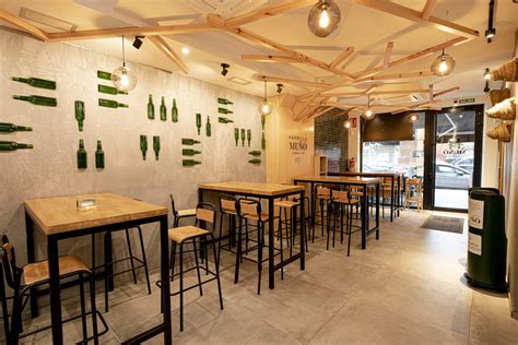 Interior de una sidrería gijonesa, con mesas llenas y un ambiente animado