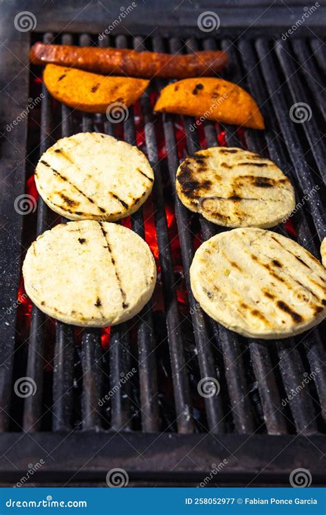 Parrilla con arepas y carnes asándose