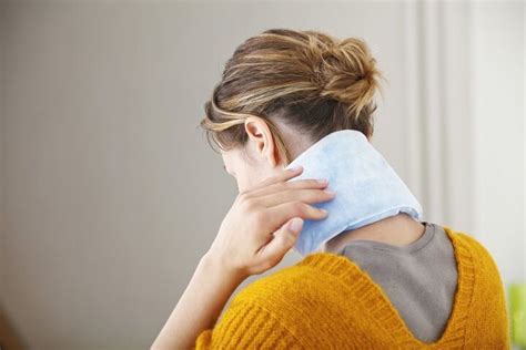 Mujer relajándose con una compresa de semillas caliente en el cuello