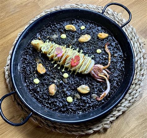 Arroz negro con calamares y gambones en paella