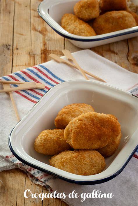 Croquetas de gallina recién fritas en un plato con papel absorbente