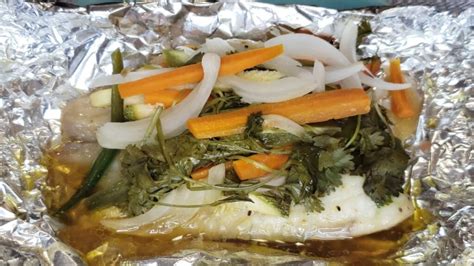 Filetes de pescado blanco cocinados al vapor en papel de aluminio