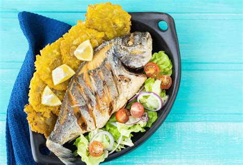 Pescado frito a la italiana con queso y hierbas en un plato con guarnición