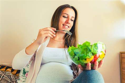 Mujer embarazada comiendo alimentos saludables
