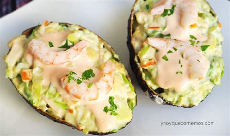 Aguacates rellenos de gambas y pimientos presentados de forma elegante
