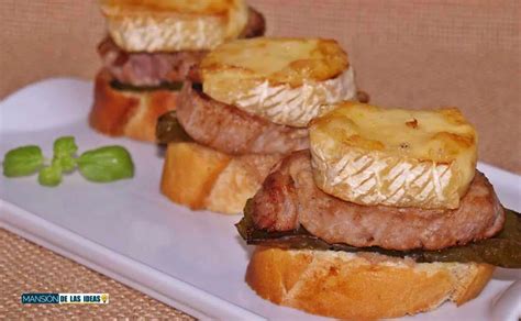 Montaditos de solomillo de cerdo y queso brie en una tabla de madera