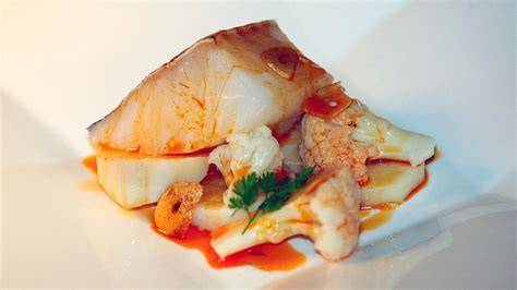 Salsa de ajada con pimentón sobre plato de bacalao