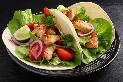 Tacos de lechuga con pollo sobre una tabla de madera