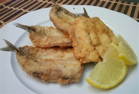 Sardinas rebozadas con guarnición de limón y perejil