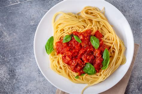 Plato de espagueti con salsa de tomate y albahaca
