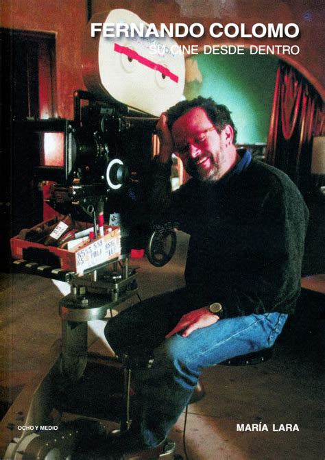 Fernando Colomo joven, con gafas y una cámara de cine antigua