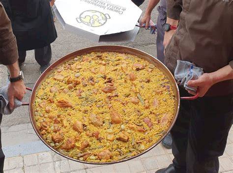 Pescadores valencianos cocinando fideuá en un barco