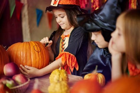 Niños decorando calabazas para Halloween
