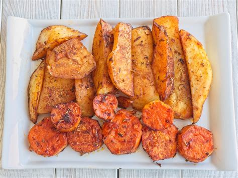 Patatas y boniatos cortados y especiados listos para hornear