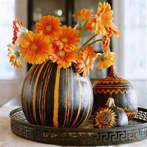 Calabazas decoradas como floreros con flores de otoño