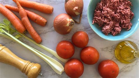 Ingredientes frescos para la salsa boloñesa (apio, zanahoria, cebolla, tomate)