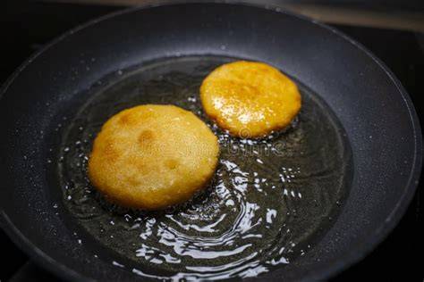 Arepas cocinándose en sartén