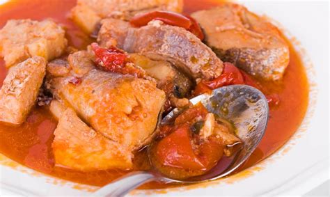 Pez espada con salsa de tomate y guisantes