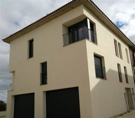Fachada moderna revestida con mortero blanco texturizado