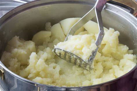 Triturar patatas cocidas para hacer puré