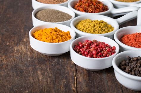 Recipientes de especias coloridas en un estante de cocina.