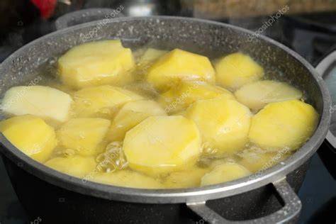 Patatas cocinándose en agua fría