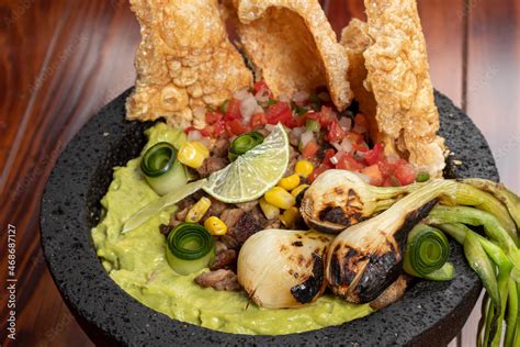 Chicharrón de queso servido con salsa pico de gallo y guacamole