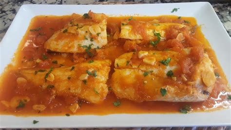 Lomos de merluza cociéndose en la salsa