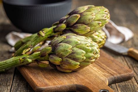 Tabla de corte con alcachofas y verduras