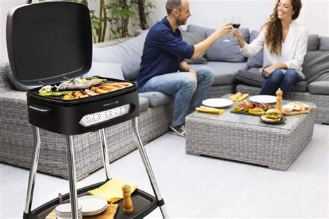 Persona ajustando los controles de una barbacoa eléctrica para optimizar la cocción