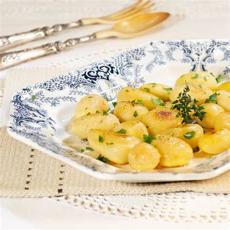 Primer plano de patatas doradas a la mantequilla con perejil