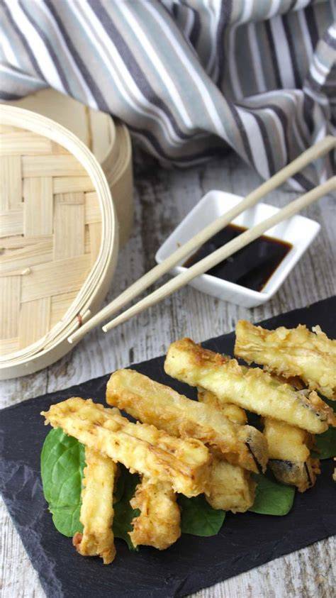 Palitos de berenjena en tempura dorados sobre papel absorbente
