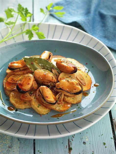 Plato de patatas panadera con mejillones en escabeche