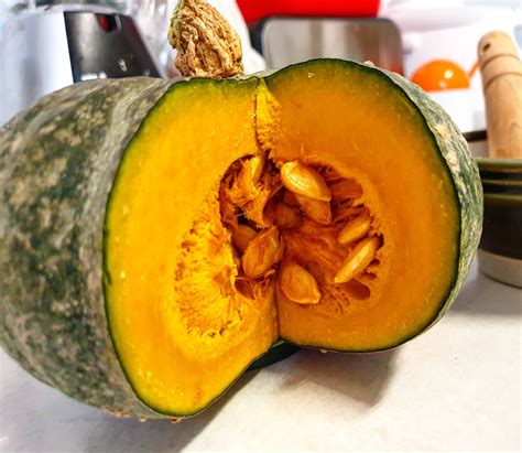 Calabaza verde potimarron cortada mostrando su interior naranja