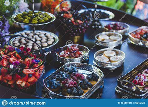 Mesa con diferentes postres y fruta fresca