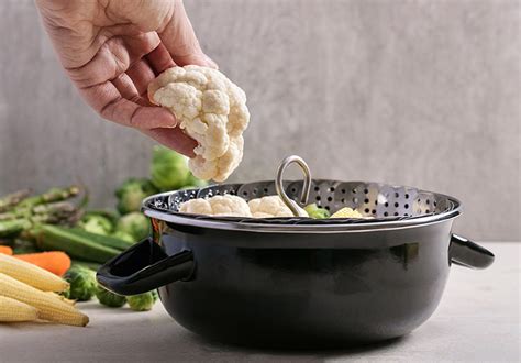Cesta vaporera con ramilletes de coliflor sobre una olla