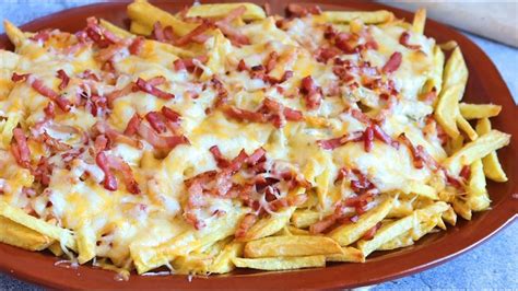 Patatas fritas con bacon y queso gratinado en una bandeja