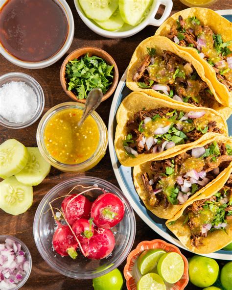 Variedad de tacos de barbacoa recién preparados con salsa y cilantro