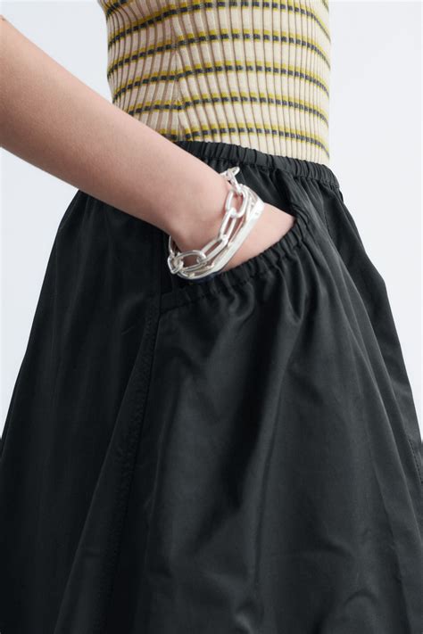 Mujer luciendo una falda midi de crepé fruncida negra