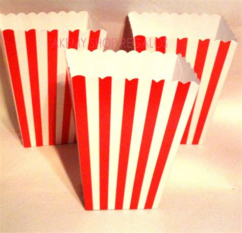 Cajitas de palomitas fucsia y blancas en una mesa de fiesta