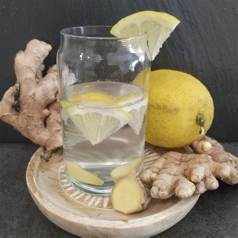 Vasos de jugo recién preparado con rodajas de limón y jengibre