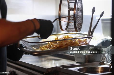Chef friendo alimentos en una freidora